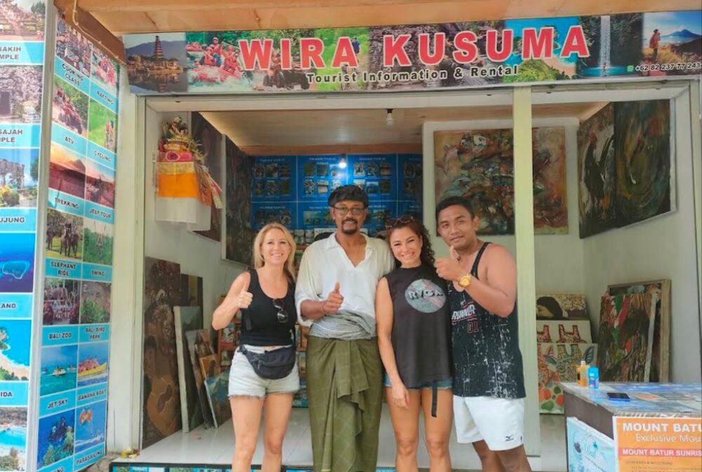 The Wira Kusuma team with happy travellers outside their Ubud tourist information stand